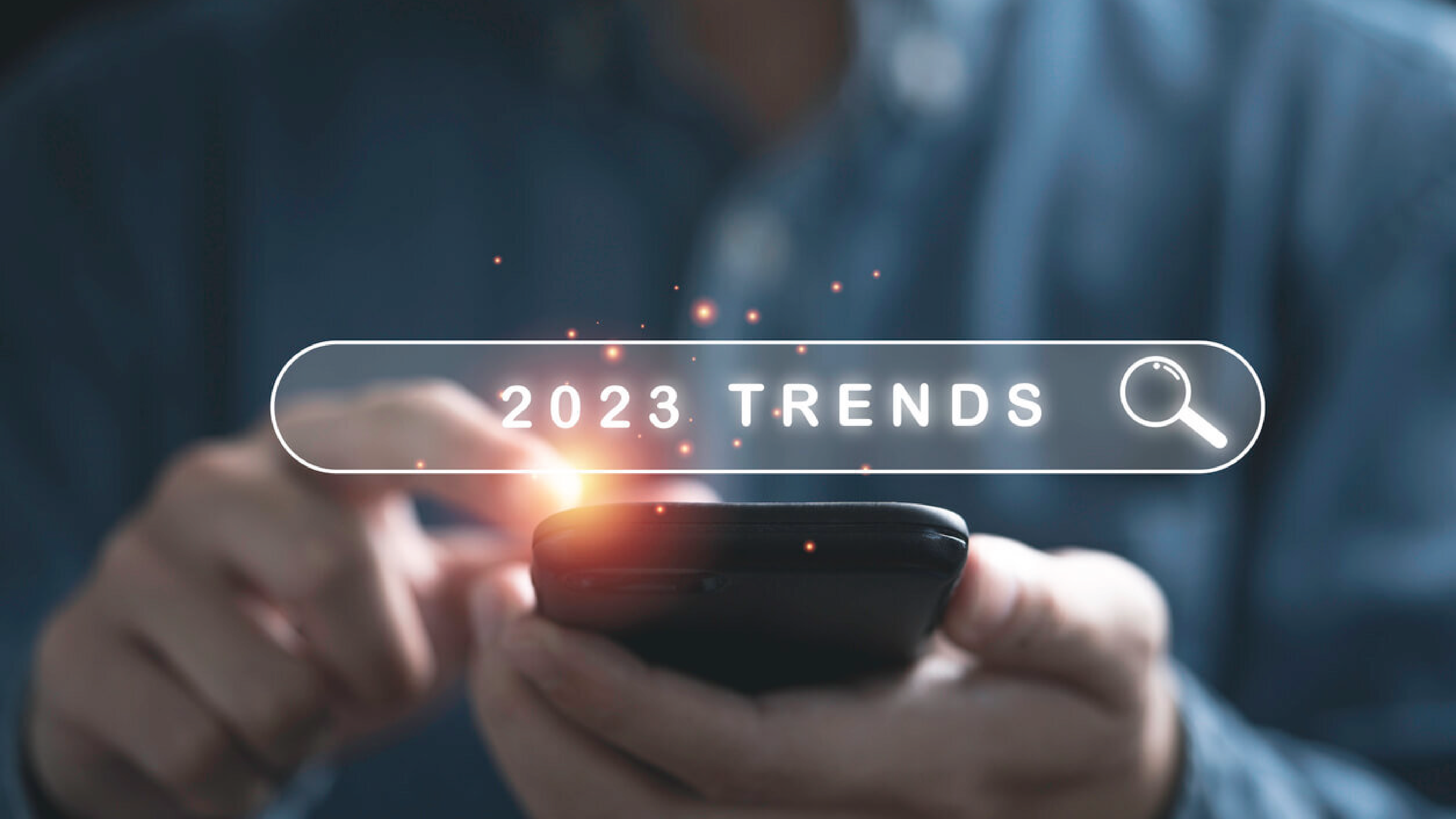Person holding phone, with title "2023 trends" displayed.