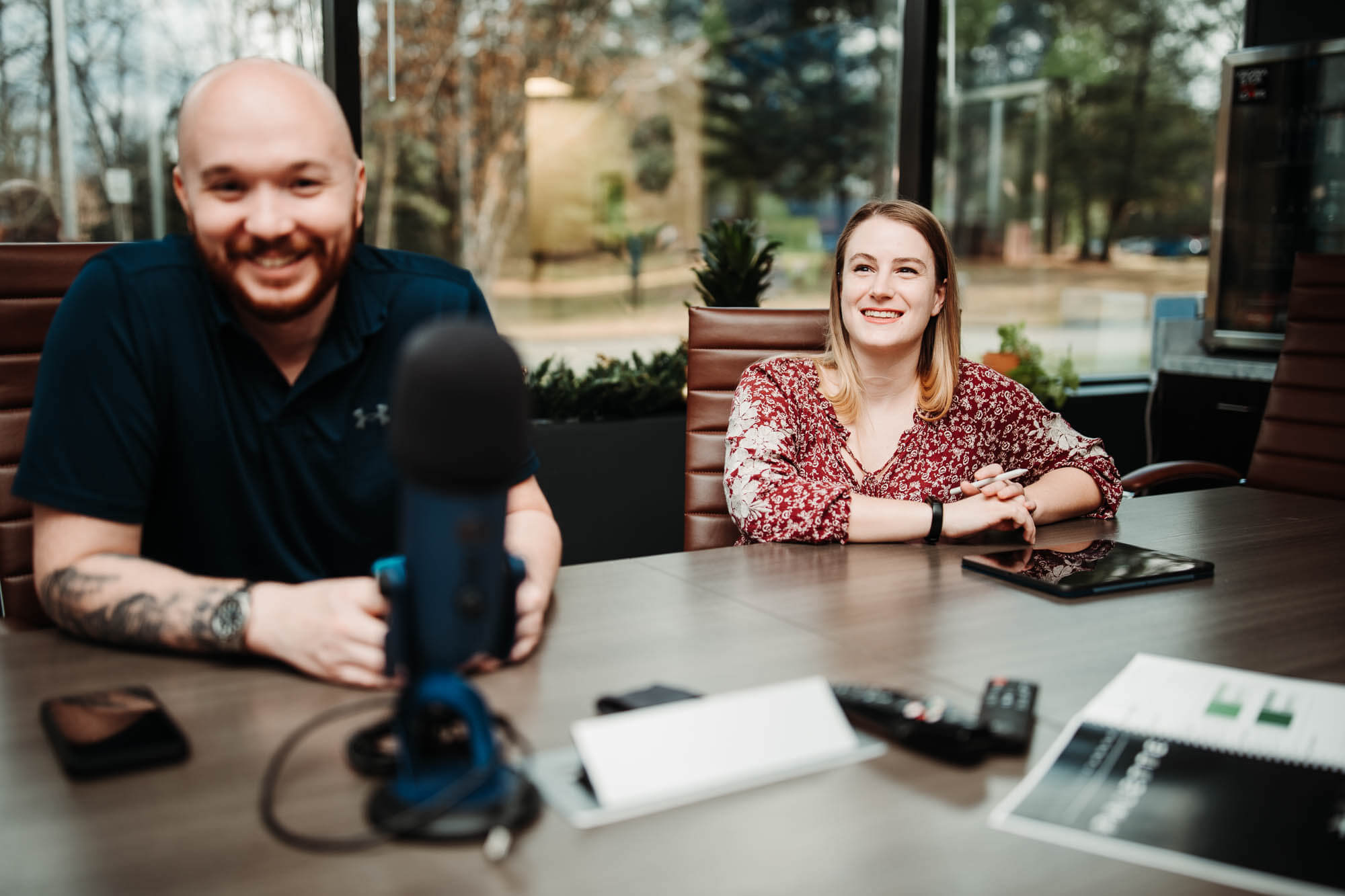 Ryan and Emily smiling around the conference table