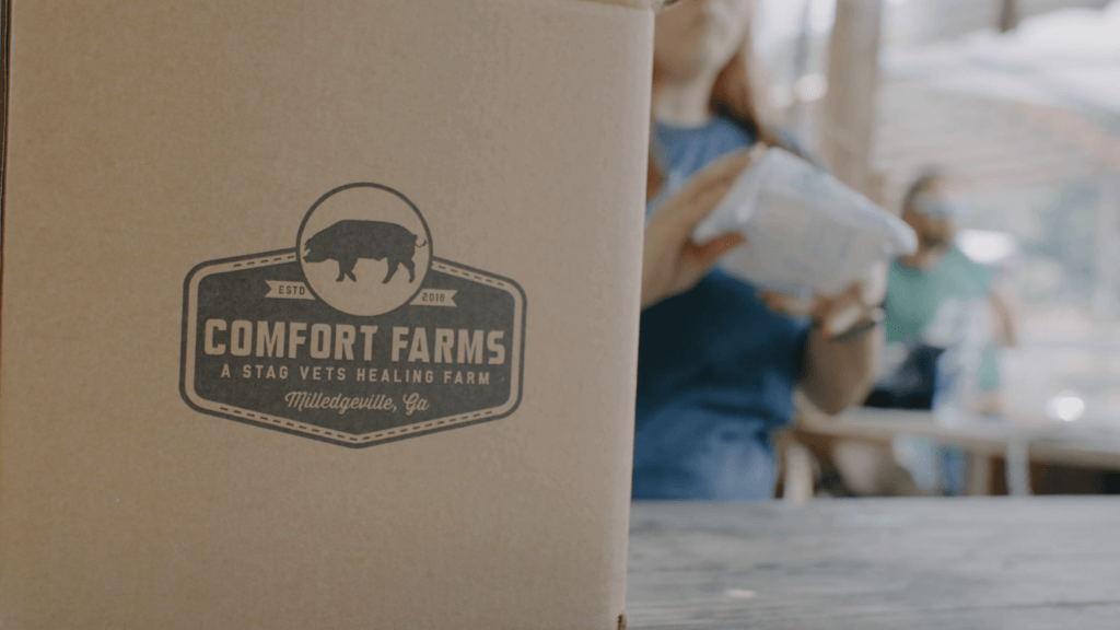 Product from the farm being boxed up in a brown box with the logo printed on the side